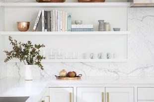 White kitchen with white open shelving. Styled with books .