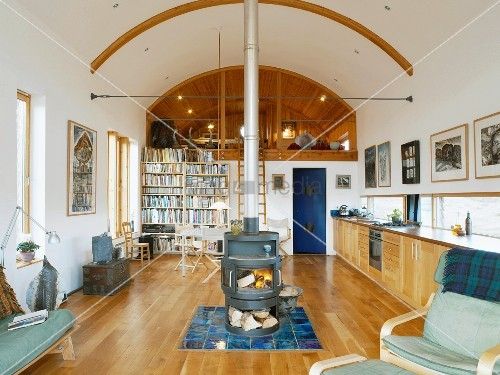 Open-plan, ecological living space with central wood-burning stove .