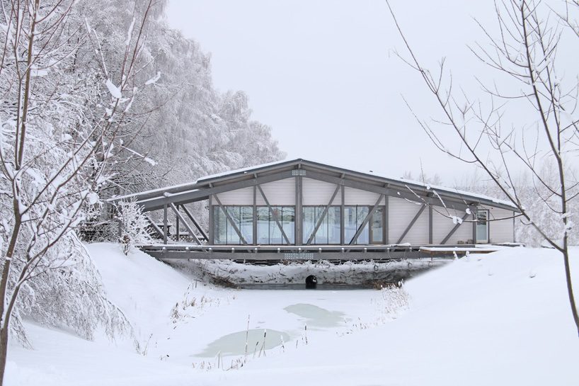 bridge house by bio-architects hovers over creek in russian fore
