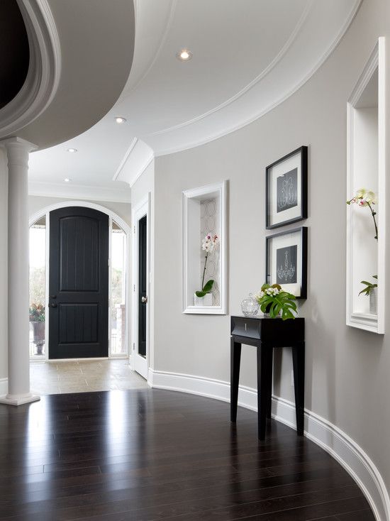 Entry with dark floors and light grey walls. Notice the wallpaper .