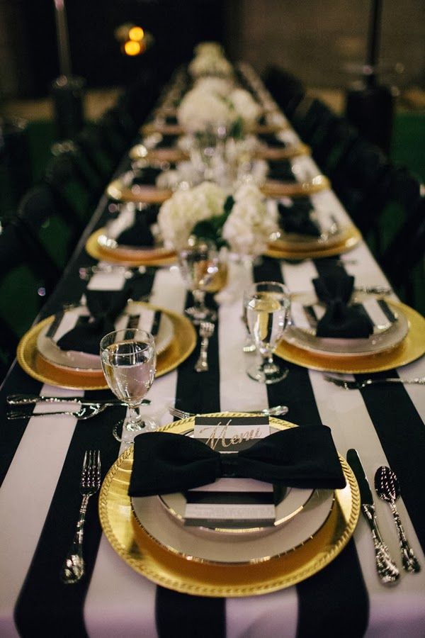 Picture Of a chic tablescape with a striped tablecloth, black .