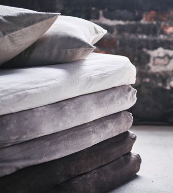 A close-up of the corner of a stack of mattresses made into a sofa .